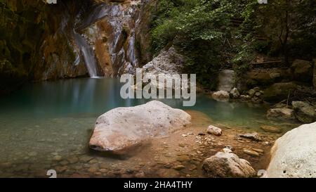 griechenland, griechische Inseln, ionische Inseln, lefkada oder lefkas, Bucht von nidri, Wasserfälle von nidri, Felsbrocken im Vordergrund, Teiche mit klarem, grünem Wasser in der Mitte, unterer Teil der Wasserfälle im Hintergrund Stockfoto