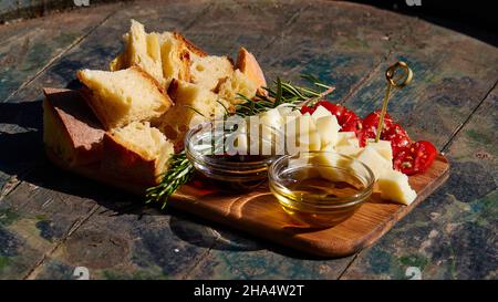 griechenland, griechische Inseln, ionische Inseln, kefalonia, Weingut, gentilini, Meze serviert auf einem Holztisch als Ergänzung zur Weinprobe, Weinflaschen aufgereiht, rot, weiß und Rose –© Stockfoto