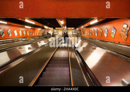 Hongkong, China, Asien - Menschen an einer Rolltreppe, die in eine U-Bahn-Station in Hongkong fährt. Stockfoto