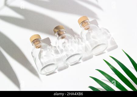 Drei Glasflaschen mit Korkstopfen für Parfüms mit exotischen Pflanzen. Modell. Stockfoto