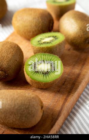 Grüne Bio-Kiwi-Früchte auf rustikalem Holzbrett, Seitenansicht. Nahaufnahme. Stockfoto