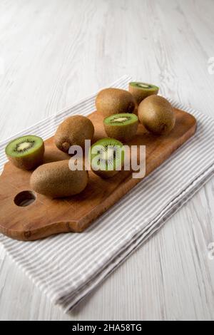 Grüne Bio-Kiwi-Früchte auf rustikalem Holzbrett, Seitenansicht. Stockfoto