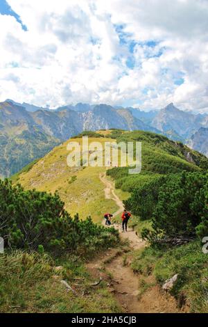 Aufstieg zum bärenkopf (1991m),Wanderweg,steinig,Wanderer auf den letzten Höhenmetern,Bergrücken,Wolkenbildung,blauer Himmel,achensee,tirol,österreich Stockfoto