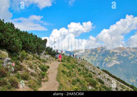 Aufstieg zum bärenkopf (1991m),Wanderweg,steinig,Wanderer auf den letzten Metern zum Gipfel,im Hintergrund Gipfelkreuz,blauer Himmel,achensee,tirol,österreich Stockfoto