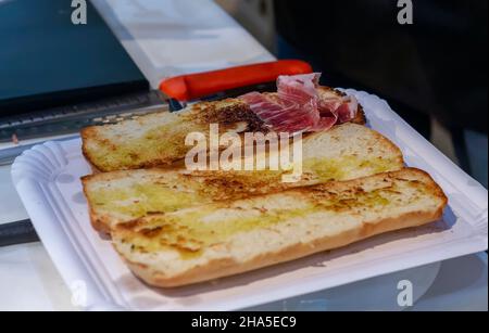 Zubereitung von Toast mit iberischem Schinken und Olivenöl typisch spanischer Küche. Stockfoto