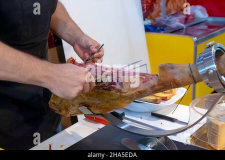 Nahaufnahme eines professionellen Schneidemaschine zum Schnitzen von Scheiben ganzen serrano-Schinken mit Knochen Stockfoto