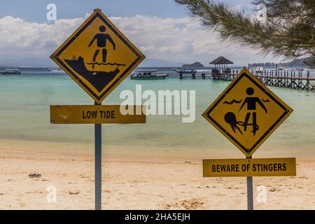 Schilder Low Tide und Vorsicht vor Stingern auf Gaya Island im Tunku Abdul Rahman National Park, Sabah, Malaysia Stockfoto
