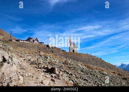 latzfons,sarntaler alpen,provinz bozen,Südtirol,italien,europa. Die Schutzhütte und die Wallfahrtskirche latzfonser kreuz (2311m), rechts im Bild die geislerspitzen 3025 m. Stockfoto