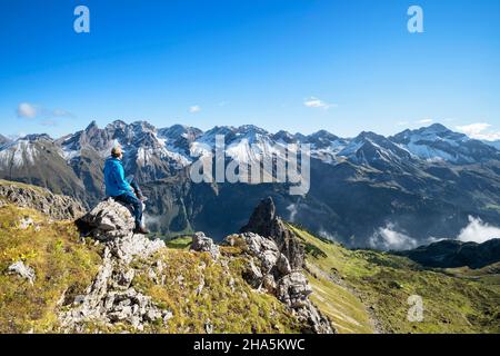 Der Mann auf dem Rossgundkopf genießt an einem sonnigen Herbsttag den Blick auf die schneebedeckten allgäuer Berge bei oberstdorf. allgäuer alpen, bayern, deutschland, europa Stockfoto