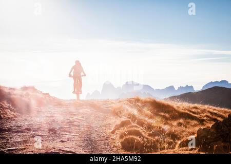 Radfahrerin auf einem E-Bike in der Umgebung des passes san pellegrino,dolomiten,Gemeinde moena,trient,trentino Alto adige Stockfoto