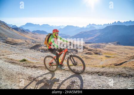 Radfahrerin auf einem E-Bike in der Umgebung des passes san pellegrino,dolomiten,Gemeinde moena,trient,trentino Alto adige Stockfoto