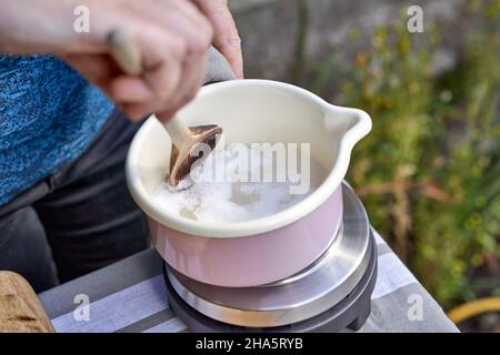 Schritte bei der Herstellung von Thymian-Bonbons wird Birkenzucker in einem Topf geschmolzen Stockfoto