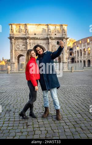 Sagen Sie Käse! Ein junges, charmantes Paar, das ein Selfie im historischen Zentrum Roms macht, in der Nähe des Titusbogens. Stockfoto