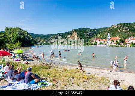 dürnstein,Badegäste am Strand an der Donau gegenüber der Burg dürnstein und dem Stift dürnstein,Boot,Schiff in wachau,niederösterreich,österreich Stockfoto