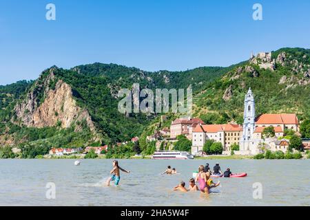 dürnstein,Badegäste am Strand an der Donau gegenüber der Burg dürnstein und dem Stift dürnstein,Boot,Schiff in wachau,niederösterreich,österreich Stockfoto