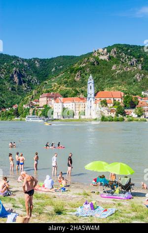 dürnstein,Badegäste am Strand an der Donau gegenüber der Burg dürnstein und dem Stift dürnstein,Boot,Schiff in wachau,niederösterreich,österreich Stockfoto