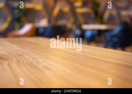 Holztisch im unscharfen, modernen Café-Hintergrund. Stockfoto