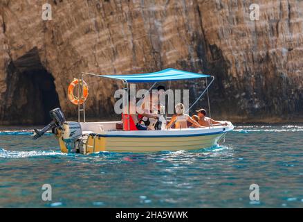 Familie auf einem kleinen Mietboot oder Mietboot in den keri Höhlen auf der griechischen ionischen Insel Zante oder Zakythos, Urlaubsfamilie in kleinen gelben Boot auf Zante Stockfoto