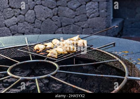 Essen, Huhn wird auf einem vulkanischen Grill zubereitet, das von césar manrique entworfene El diablo Besucherzentrum, der nationalpark timanfaya, der parque nacional de timanfaya, montanas del fuego, lanzarote, Kanaren, kanarische Inseln, spanien, europa Stockfoto