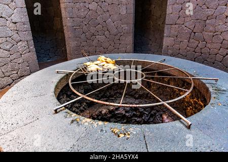 Essen, Huhn wird auf einem vulkanischen Grill zubereitet, das von césar manrique entworfene El diablo Besucherzentrum, der nationalpark timanfaya, der parque nacional de timanfaya, montanas del fuego, lanzarote, Kanaren, kanarische Inseln, spanien, europa Stockfoto