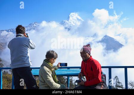 Die Reisenden machen Fotos von Schneespitzen im Himalaya per Handy und Kamera. Wunderschöne Aussicht auf South Annapurna in Dobato, Nepal April 2021 Stockfoto