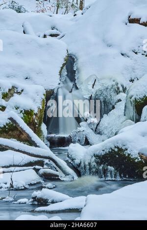 Eiszapfen am Ufer, wilder Fluss höllbach, der im Winter durchfließt, Naturschutzgebiet hölle, bayern, deutschland Stockfoto