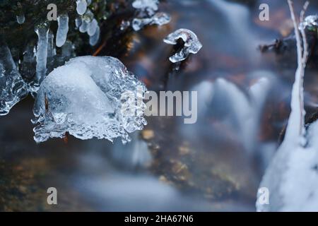 Eiszapfen am Ufer, wilder Fluss höllbach, der im Winter durchfließt, Naturschutzgebiet hölle, bayern, deutschland Stockfoto