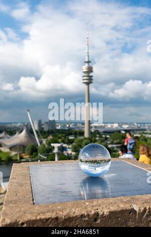 Auf der Metallplatte des geodätischen Referenzpunktes auf dem olympiaberg in münchen liegt eine Glaskugel. Stockfoto