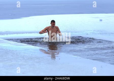 Schwimmen im Winter. Aushärtung. Männer schwimmen in einem mit Eis bedeckten Winterfluss während der orthodoxen Feiertage Epiphanie. Dnipro Stadt, Dnepropetrovsk Stockfoto