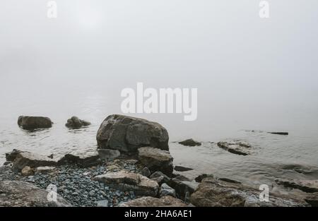 Felsiger Strand des Lake Ontario an einem grauen nebligen Tag. Stockfoto