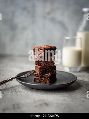 Stapel Schokolade Brownies auf einem Teller mit Glas Milch. Stockfoto