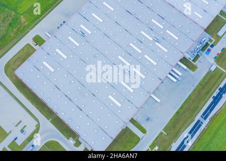 Luftaufnahme von Warenlager. Logistik Zentrum in der industriellen Zone der Stadt von oben. Luftaufnahme von Lkw beladen am Logistikzentrum Stockfoto