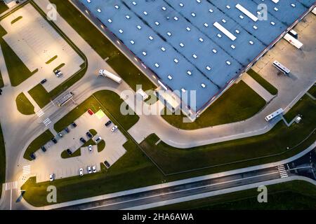 Nacht Luftaufnahme des Warenlagers. Logistikzentrum im industriellen Stadtgebiet von oben. Luftaufnahme der LKW-Verladung im Logistikzentrum Stockfoto