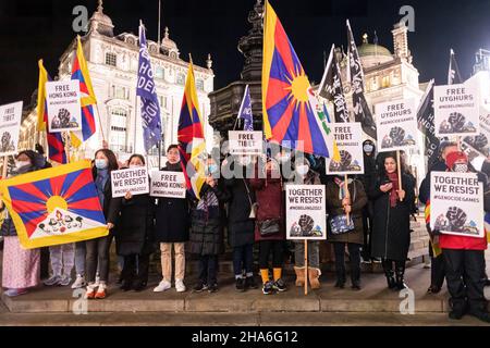 London, Großbritannien. 10th Dez 2021. Die Demonstranten sahen während des Protestes Plakate und Flaggen halten. Zur Feier des Menschenrechtstages (10th. Dezember) versammelten sich verschiedene Gruppen gegen die Kommunistische Partei Chinas (gegen die KPCh) in London am Piccadilly Circus und marschierten später zur Downing Street 10. Die Kundgebung forderte die westliche Welt majorly auf, die Olympischen Winterspiele 2022 in Peking zu boykottieren. Stockfoto