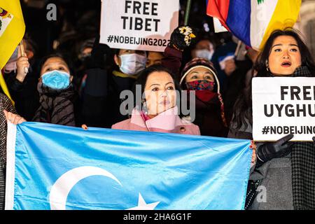 London, Großbritannien. 10th Dez 2021. Rahima Mahmut (C), britische Direktorin des Welt-Uiguren-Kongresses und Exekutivdirektorin des Stop-Uiguren-Genozids, sah während des Protestes, wie sie die Uiguren-Flagge hielt. Zur Feier des Menschenrechtstages (10th. Dezember) versammelten sich verschiedene Gruppen gegen die Kommunistische Partei Chinas (gegen die KPCh) in London am Piccadilly Circus und marschierten später zur Downing Street 10. Stockfoto