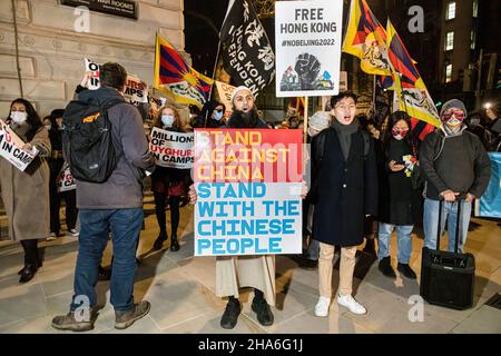 London, Großbritannien. 10th Dez 2021. Die Demonstranten versammelten sich auf der Downing Street 10 und hielten Plakate mit der Aufschrift „steht gegen China“. Stehe mit dem chinesischen Volk“ und „Freier Hongkong. Kein Peking 2022'. Zur Feier des Menschenrechtstages (10th. Dezember) versammelten sich verschiedene Gruppen gegen die Kommunistische Partei Chinas (gegen die KPCh) in London am Piccadilly Circus und marschierten später zur Downing Street 10. Stockfoto