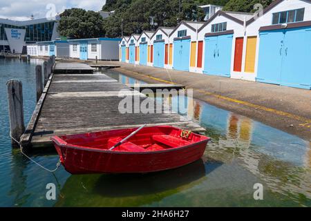 Red Dingy vor Blue Boat Sheds, Boat Harbour, Wellington, North Island, Neuseeland Stockfoto