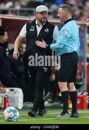 Köln, Deutschland. 10th Dez 2021. Der Linesman (R) spricht mit Steffen Baumbart (L), Cheftrainer von Köln beim Bundesliga-Fußballspiel zwischen Augsburg und dem FC Köln im RheinEnergie-Stadion in Köln (Endstand; Augsburg 2:0 FC Köln) (Foto: Osama Faisal/SOPA Images/Sipa USA) Quelle: SIPA USA/Alamy Live News Stockfoto