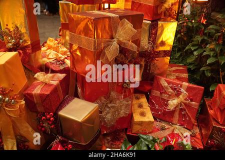 Wunderschön eingewickelte Weihnachtsgeschenke in Gold und Rot Stockfoto