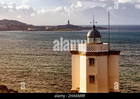 Kleiner Leuchtturm am Kap von Mera mit dem römischen Leuchtturm Torre de Hercules, einem Weltkulturerbe gegenüber in der Nähe von Serantes, Einer Provinz von Coruña, GA Stockfoto