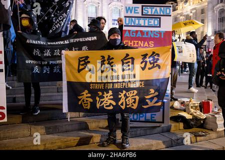 Während eines Protestes wird ein Protestler mit einem Transparent mit der Aufschrift „Hong Kong Nation, Strive for Independence“ gesehen. Verschiedene Gemeinden gegen die Kommunistische Partei Chinas (gegen die KPCh) in London versammelten sich am Piccadilly Circus und marschierten später zur Downing Street 10. Hongkong, Tibeter und Uiguren kamen zusammen, um die Versuche der KPCh zu verurteilen, abweichende Stimmen zu unterdrücken. Die Demonstranten forderten auch die westliche Welt auf, die Olympischen Winterspiele 2022 in Peking als Reaktion auf die Unterdrückung der Menschenrechte in China zu boykottieren. (Foto von Hesther Ng/SOPA Images/Sipa USA) Stockfoto