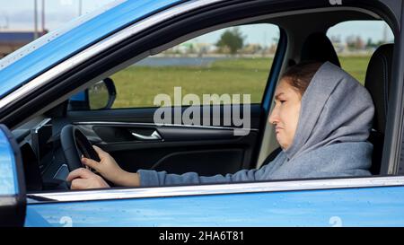 Lady Driver sitzt im Auto deprimiert an düsteren Herbsttag Stockfoto