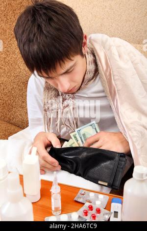 Kranker Teenager, der die Brieftasche auf dem Sofa zu Hause überprüft Stockfoto