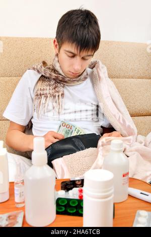 Kranker Teenager, der die Brieftasche auf dem Sofa zu Hause überprüft Stockfoto