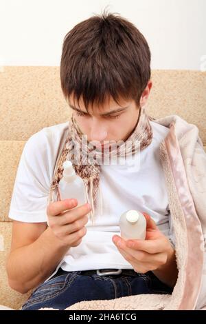 Kranke Teenager wählen die Medizin auf dem Sofa zu Hause Stockfoto