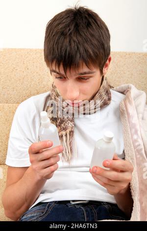 Kranke Teenager wählen die Medizin auf dem Sofa zu Hause Stockfoto