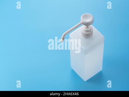 Eine Flasche alkoholdesinfizierenden Sprays auf einem blauen Hintergrund im Kopierbereich. Bild von Desinfektion und Hygiene. Stockfoto