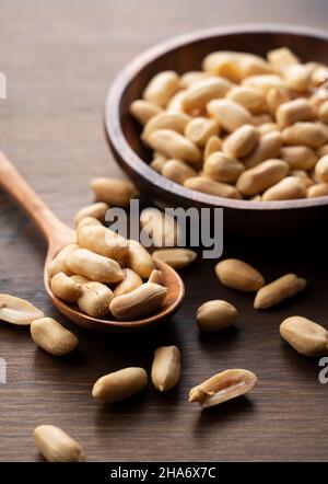 Erdnüsse in einer Holzschale auf einem Holztisch. Stockfoto