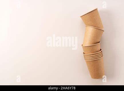 Einweg-Pappbecher auf beigefarbenem Hintergrund. Ein Zero-Waste-Konzept. Blick von oben. Stockfoto