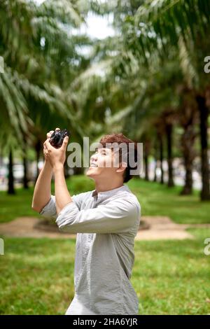 Junger attraktiver Mann, ein Fotograf, der in einem städtischen Gebiet fotografiert Stockfoto